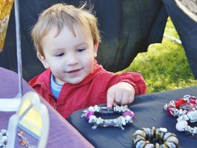 Joshua Aguia is shown in this file photo checking out some jewelry at Bright Grove's Art in the Park in September 2013. This year's Art in the Park is set for Saturday, 9 a.m. to 4 p.m., in Mike Weir Park. (File photo)