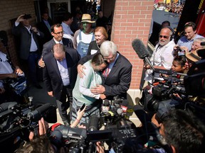 Rowan County clerk Kim Davis, centre, hugs her attorney, Matt Staver, with Republican presidential candidate Mike Huckabee, centre left, next to her after being released from the Carter County Detention Center, Tuesday, Sept. 8, 2015, in Grayson, Ky. (Jonathan Palmer/The Courier-Journal via AP)