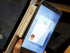 An employee demonstrates a Samsung Pay, Samsung's new mobile payment system at a shop in Seoul, South Korea, Sept. 4, 2015. REUTERS/Kim Hong-Ji