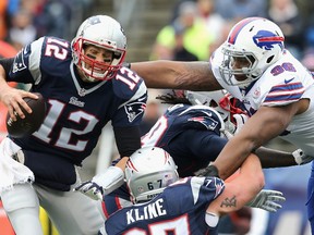 Tom Brady #12 of the New England Patriots is tackled by Stefan Charles #96 of the Buffalo Bills during the second quarter at Gillette Stadium on December 28, 2014 in Foxboro, Massachusetts.   Jim Rogash/Getty Images/AFP