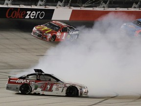 Kurt Busch (41) spins in turn four as Jamie McMurray (1) and Aric Almirola (43) drive by during NASCAR Sprint Cup Southern 500 at Darlington Raceway in Darlington, S.C., on Sunday, Sept. 6, 2015. (AP Photo/Terry Renna)