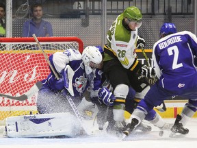Sudbury Wolves goalie prospect Matthew Menna looks for the puck between the legs of teammate Trenton Bourque (2) as North Bay Battalion's Mathew Santos attempts to score during the first period of OHL pre-season play at Memorial Gardens this past September. Postmedia Network file photo