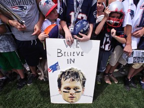 In this July 30, 2015, file photo, New England Patriots fans wait for practice to complete, while standing behind a sign supporting quarterback Tom Brady, during an NFL football training camp in Foxborough, Mass. (AP Photo/Charles Krupa, File)