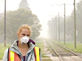 Kristy Duquette wears a mask to keep from inhaling smoky air. (Postmedia)