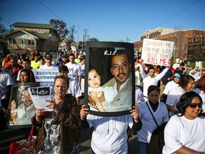 In this Feb. 14, 2015, file photo, marchers carry photos of police shooting victim Antonio Zambrano-Montes during a rally in Pasco, Wash. A witness said Zambrano-Montes appeared to be trying to put down a rock when three police officers shot him to death in February, according to investigative documents released Wednesday, July 1, 2015. (Joshua Trujillo/seattlepi.com via AP, File)
