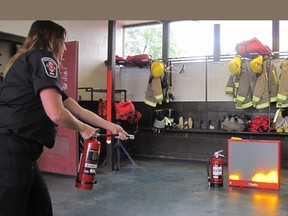 Whitney Burk, a public educator with Chatham-Kent Fire and Emergency Services, demonstrates a laser-driven fire extinguisher that is part of a new system that will help the service train more people across the community on the proper use of fire extinguishers.