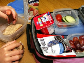 Fresh tomatoes, cucumber slices, grapes, yogurt and a sandwich made with whole wheat bread comprise this nutritious school lunch.
(Postmedia Network file photo)