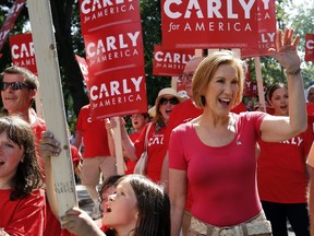 Republican presidential candidate Carly Fiorina, the former Hewlett-Packard chief executive, waves as she and supporters march in the Labor Day parade Monday, Sept. 7, 2015, in Milford, N.H. (AP Photo/Jim Cole)
