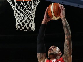 Canada’s Robert Sacre goes up for a dunk over the Dominican Republic’s Edward Santana yesterday in Mexico City. Canada won 120-103. (Christian Palma/The Associated Press)