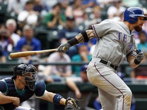 Texas Rangers' Josh Hamilton, right, hits an RBI-single during the 11th inning of a baseball game against the Seattle Mariners, Saturday, Aug. 8, 2015, in Seattle.  (AP Photo/Joe Nicholson)