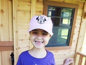 Six-year-old leukemia patient Tahnee Henry poses with her new playhouse. The playhouse and its construction were the result of work done by Winnipeg-based The Dream Factory. (SUPPLIED PHOTO)