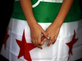 A girl holds a Syrian opposition flag.

REUTERS/Jon Nazca