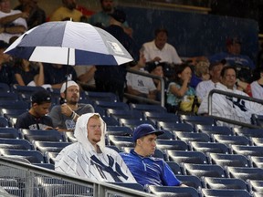 Fans wait out a rain delay before the game between the New York Yankees and the Texas Rangers at Yankee Stadium in New York on August 15, 2012. (Jim McIsaac/Getty Images/AFP)