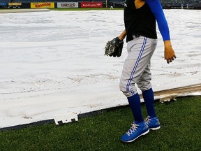 Toronto Blue Jays pitcher David Price walks to the outfield as a tarp covers the field after his team's game against the New York Yankees on Sept. 10, 2015, was postponed due to rain. (JIM McISAAC/Getty Images/AFP)