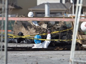 Workers clean up at the Essence in Windermere South project in Edmonton, Alta., on Monday, April 7, 2014. Edmonton Police Service members said on Monday that the fire that destroyed the Cove Properties complex on March 15, 2014 was an arson. Ian Kucerak/Edmonton Sun/QMI Agency