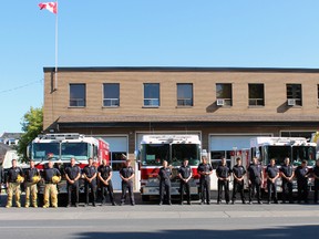 MP Ted Hsu (far right) and 22 Kingston Fire and Rescue firefighters from stations on Brock Street, Palace Road and Railway Street, stand in silence in Kingston, Ont. on Friday September 11, 2015 to remember and honour those lost during the 9/11 attacks on the World Trade Centre in New York City. Steph Crosier/Kingston Whig-Standard/Postmedia Network