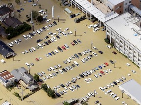 An aerial view shows a parking lot and the Joso municipal government building flooded by the Kinugawa river, caused by typhoon Etau in Joso, Ibaraki prefecture, Japan, in this photo taken by Kyodo September 11, 2015. Floods that swept houses off foundations and crushed them under landslides spread across Japan on Friday as more rivers burst their banks, leaving at least 23 people missing and forcing more than 100,000 to flee. Mandatory credit REUTERS/Kyodo
