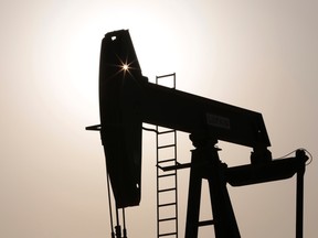 An oil pump works at sunset Thursday, July 16, 2015, in the desert oil fields of Sakhir, Bahrain. (AP Photo/Hasan Jamali)