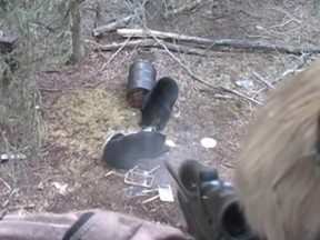 A nine-year-old Alberta boy takes aim at a baited black bear in a video his father posted to YouTube last year. The video has resurfaced in British newspapers and is drawing ire from all over. (TouTube)