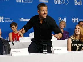Actor Matt Damon demonstrates the easy way to do acting in space with director Ridley Scott (l) and Jessica Chastain watching at the press conference for the film The Martian during the Toronto International Film Festival in Toronto on Friday September 11, 2015. Michael Peake/Toronto Sun/Postmedia Network