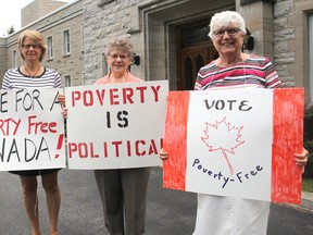 Bridget Doherty, left, Sister Shirley Morris and Sister Pauline Lally stand in front of the motherhouse of the Sisters of Providence of St. Vincent de Paul in Kingston, Ont. on Thursday, Sept. 10, 2015 holding signs for the Friday vigil that will end after 20 years. Michael Lea/The Whig-Standard/Postmedia Network