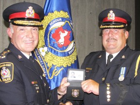 Jeff Littlewood, right, accepts the Deputy Chief badge from Chatham-Kent police Chief Gary Conn during Friday's swearing-in ceremony at the Chatham courthouse. (Blair Andrews, Postmedia Network)