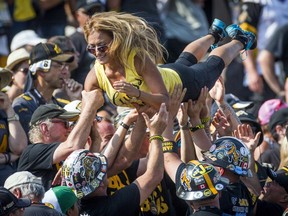 Fans hold up a woman as they watch the Toronto Argonauts play the Hamilton Tiger-Cats during the second half of their CFL football game in Hamilton on Sept. 7, 2015. (REUTERS/Mark Blinch)