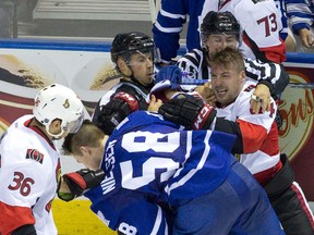 Senators’ Travis Ewanyk is held back by referees as he goes after Maple Leafs’ Andrew Nielsen in London, Ont., last night. (Craig Glover/Postmedia Network)