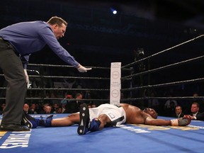 The referee counts down to 51-year-old Donovan (Razor) Ruddock after he was knocked out by Dillon (Big Country) Carman last night in the third round. (Peter Power/The Canadian Press)