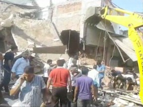 In this frame grab from video, people help at the scene after an explosion at a restaurant, Saturday, Sept. 12, 2015, in Petlawad, India. (AP Photo/AP video)