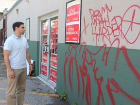 London North Centre Liberal candidate Peter Fragiskatos looks at the graffiti vandals left on his Adelaide Street North campaign headquarters. (DALE CARRUTHERS, The London Free Press)