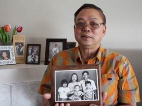 Caption: Trieu Nghien holds a picture of his family, in his apartment in Edmonton on Sept. 10, 2015, shortly before they fled Vietnam after the Communist Party of Vietnam took control of the country in 1975. Considering himself, "lucky" to have settled in Canada, Nghien says he hopes Canadians will once again open their arms, this time for Syrian refugees in crisis. CLAIRE THEOBALD/EDMONTON SUN