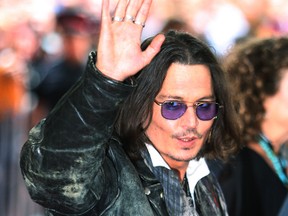 Johnny Depp gives a wave to the fans on the  Red carpet at TIFF in 2012.  (Craig Robertson/Toronto Sun)