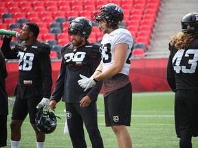 Ottawa RedBlacks' James Green (38) chats with receiver Scott Macdonell during practice Thursday at TD Place.
TIM BAINES/OTTAWA SUN