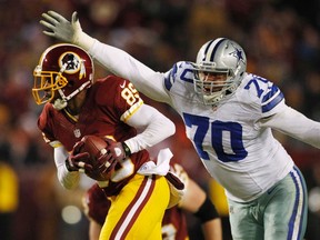 Washington Redskins receiver Santana Moss escapes the arms of Dallas Cowboys defensive tackle Tyrone Crawford in the second half of their game in Landover, Maryland on December 30, 2012. (REUTERS/Gary Cameron)