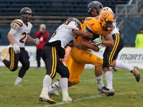 Queen's receiver Rudy Uhl does his part battling past the Waterloo Warriors to go on to score a touch-down, contributing to the Gaels win over the Warriors 47-24 Kingston, Ont. on Saturday September 12, 2015. Steph Crosier/Kingston Whig-Standard/Postmedia Network