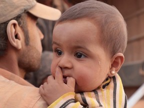 A young Syrian refugee covered with dust arrives with her family in the eastern town of Ruwaished where they are welcomed and checked by the Jordanian authorities after a 120-kilometre drive from a makeshift camp on the border with Syria on September 10, 2015. The latest batch of refugees from neighbouring Syria will be sent from Ruwaished, around 380 km from the capital Amman, to various refugee camps and temporary settlements across the country.