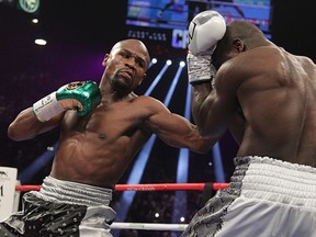 Floyd Mayweather Jr. (L) lands on punch on Andre Berto during the fight for the WBO Welterweight World Title at the MGM Grand Garden Arena in Las Vegas, Nevada on September 12, 2015.  Floyd Mayweather earned a unanimous decision over Andre Berto to claim his 49th and he says final victim in a glittering unbeaten ring career spanning two decades.  (AFP PHOTO/JOHN GURZINSKI)