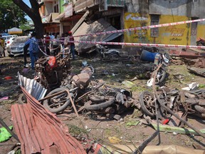 A crowd gathers at the site of an explosion near damaged motorbikes in Petlawad district, in the central Indian state of Madhya Pradesh, Saturday, Sept. 12, 2015.  (AP Photo/Ritesh Trivedi)