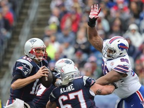Tom Brady #12 of the New England Patriots is tackled by Stefan Charles #96 of the Buffalo Bills during the second quarter at Gillette Stadium on December 28, 2014 in Foxboro, Massachusetts.   Jim Rogash/Getty Images/AFP