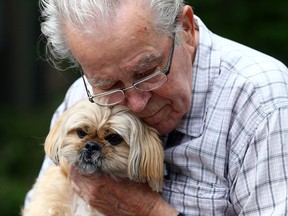 Hans Wallenwein gives Mitsy a hug during National Dog Day at Donway Place Retirement Centre in Toronto on Wednesday August 26, 2015. (Dave Abel/Toronto Sun)