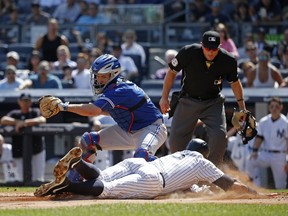 Alex Rodriguez of the New York Yankees scores ahead of the tag by Josh Thole of the Toronto Blue Jays at Yankee Stadium in New York on Sept. 13, 2015. (Adam Hunger/Getty Images/AFP)