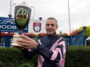Mondialiste jockey Fergal Lynch poses for a photo with the trophy following his win in the $1 million purse Ricoh Woodbine Mile at Woodbine Racetrack in Toronto Sept. 13, 2015. (THE CANADIAN PRESS/HO-Woodbine Racetrack, Michael Burns)
