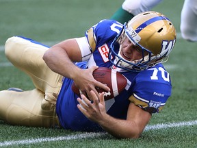 Lirim Hajrullahu hits the turf hard after being forced to run with the ball on a bobbled snap on Saturday. (KEVIN KING/Winnipeg Sun)