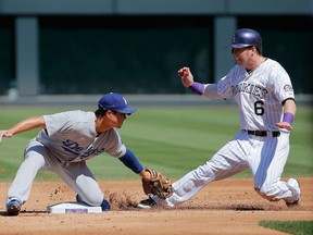 Corey Dickerson of the Colorado Rockies is tagged out by Darwin Barney of the Los Angeles Dodgers at Coors Field in Denver on September 17, 2014. (Doug Pensinger/Getty Images/AFP)