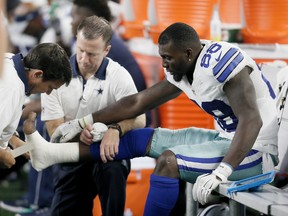 Dallas Cowboys wide receiver Dez Bryant (88) is tended to on the sideline after injuring his foot during the second half of an NFL football game against the New York Giants Sunday, Sept. 13, 2015, in Arlington, Texas. (AP Photo/Brandon Wade)