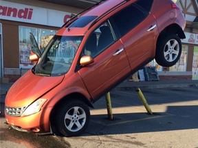 Peel police say a driver was in rush when his SUV got stuck on a pole in a Brampton parking lot Monday, Sept. 14, 2015. (Peel Regional Police handout)
