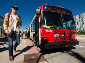 Passengers get on and exit an OC Transpo bus at the Baseline Transitway Station on Monday September 14, 2015. 
Errol McGihon/Ottawa Sun