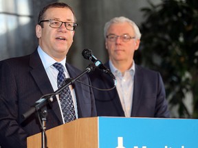 Manitoba Hydro interim CEO Darren Rainkie (l) and Premier Greg Selinger announce a 20-year hydro sale deal with SaskPower during a press conference in Winnipeg, Man. Monday Sept. 14, 2015.