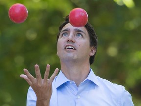 Liberal Leader Justin Trudeau juggles bocce balls during campaign stop in Fred Hamilton Park in Toronto, Monday, Sept. 14, 2015. (THE CANADIAN PRESS/Jonathan Hayward)